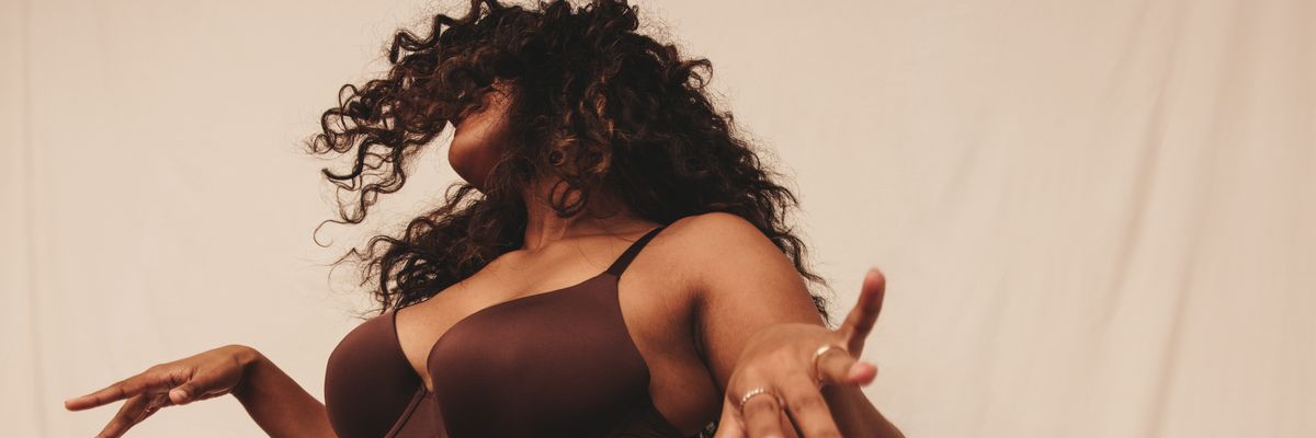 Confident young woman dancing in brown underwear, embracing body confidence and celebrating the crotch cleavage fashion trend