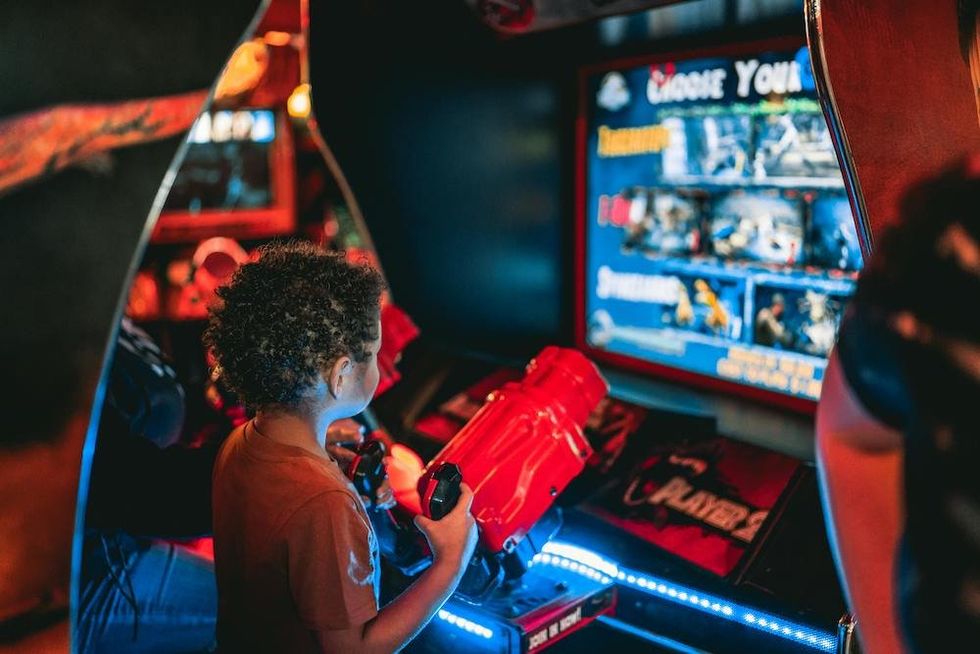 photo of A Young Boy Playing Arcade Game