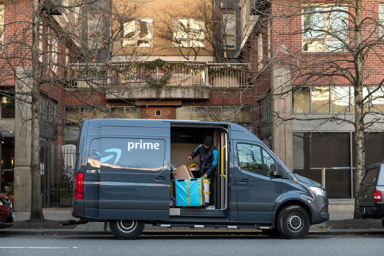 a photo of Amazon van and driver making a delivery