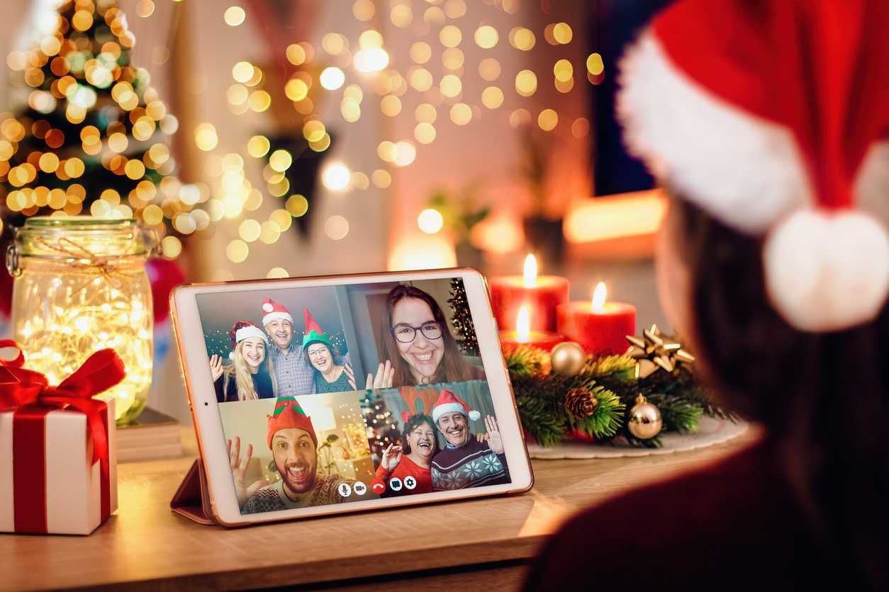 a young woman having a Christmas video call with her happy family