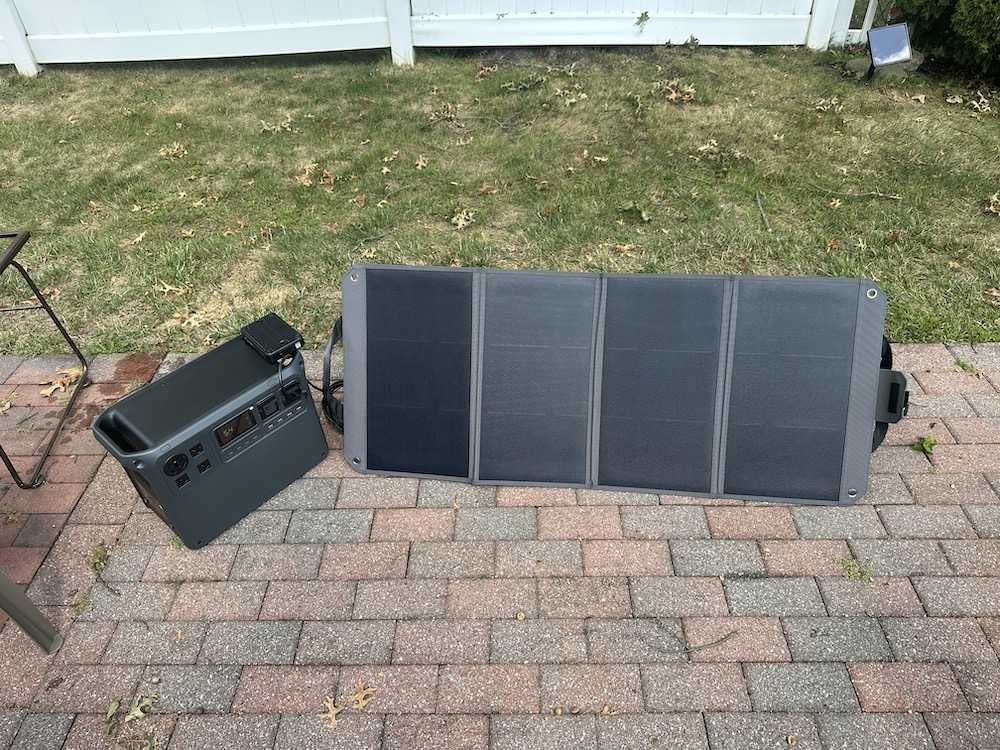 a photo of DJI Power 2000 connected to Zignes 100W solar panel on a patio in the sunlight.