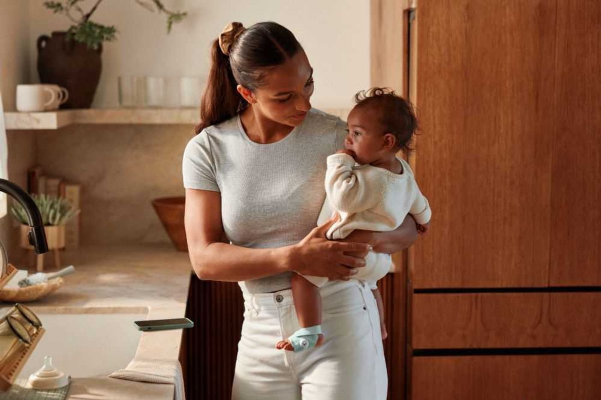 photo of a mother holding a baby with Owlet Sock