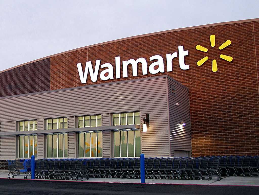 photo of the outside of a Walmart Store with shopping carts lined up.
