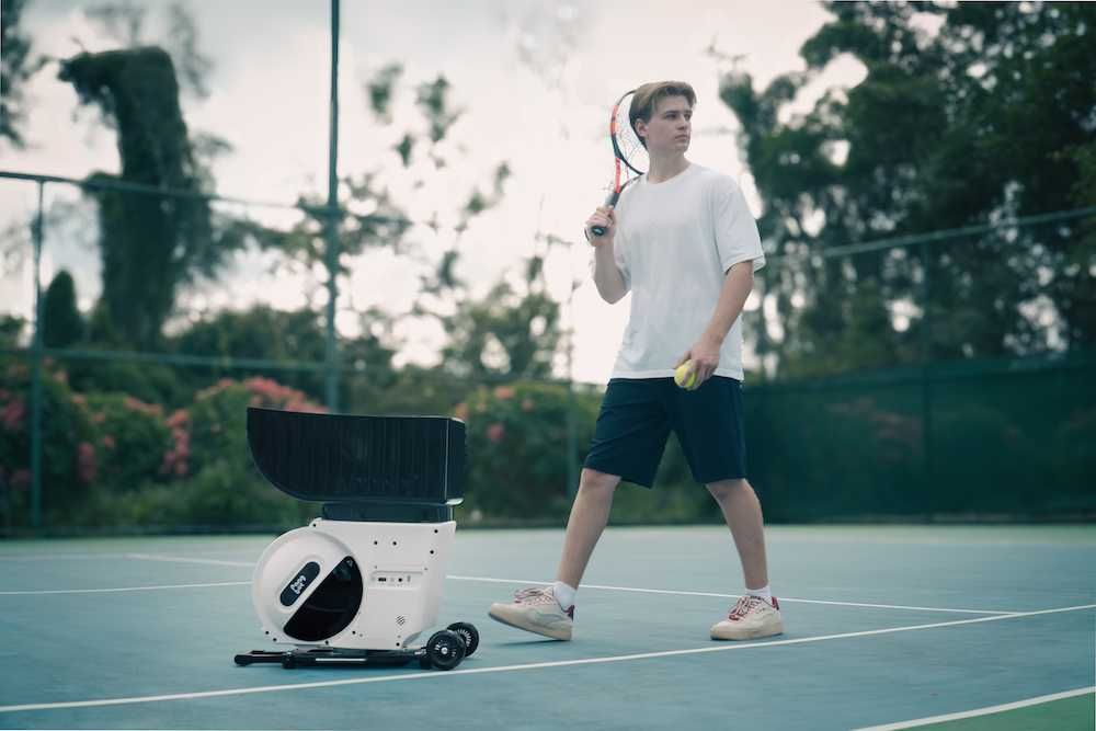 photo of a male tennis play with Pongbot Pace S Pro on a tennis court