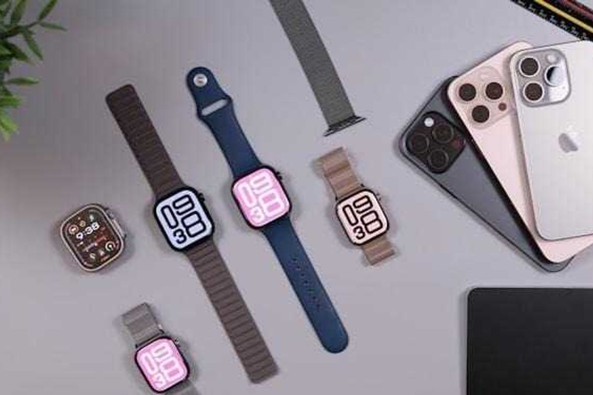 Apple watches and iphones arranged on a desk.