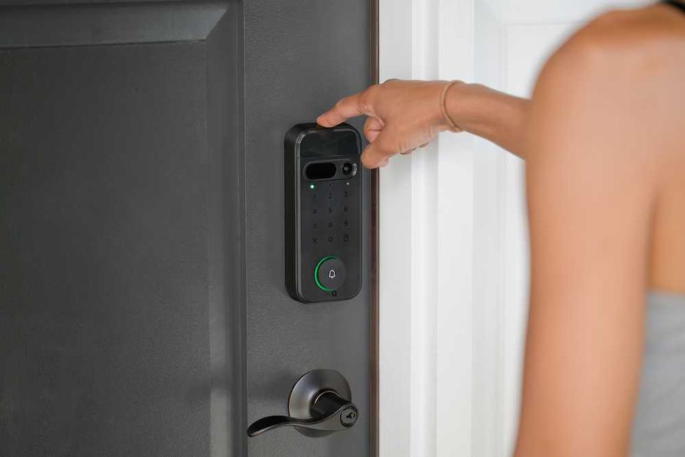 a photo of a woman using her finger to unlock myQ SecureView smart lock