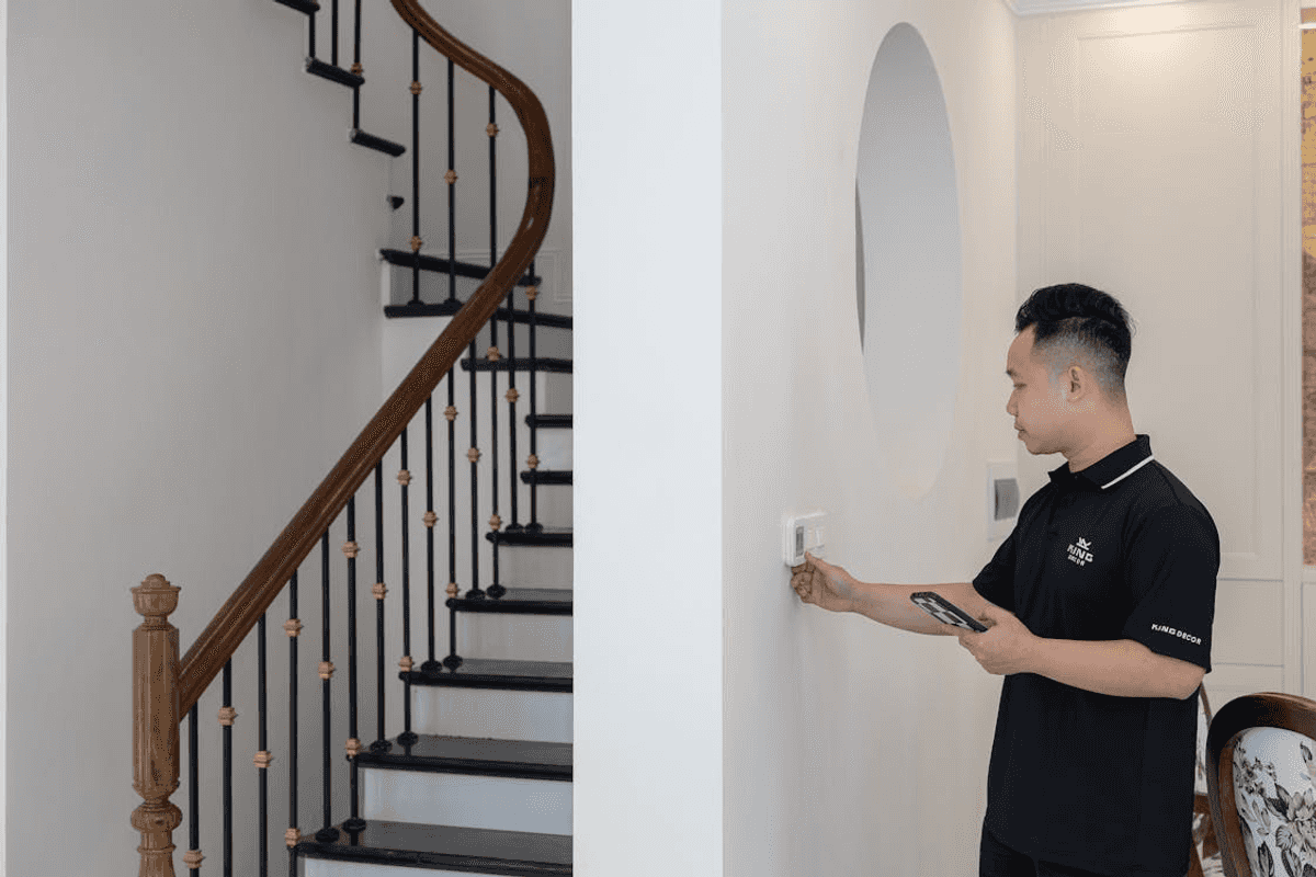 a man checking a smart thermostat in a house