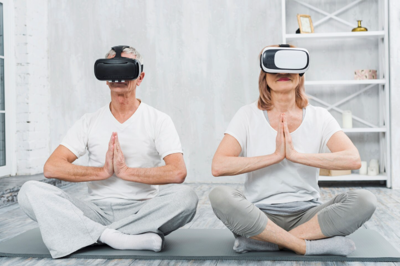 a couple sitting in yoga class with vr headsets on