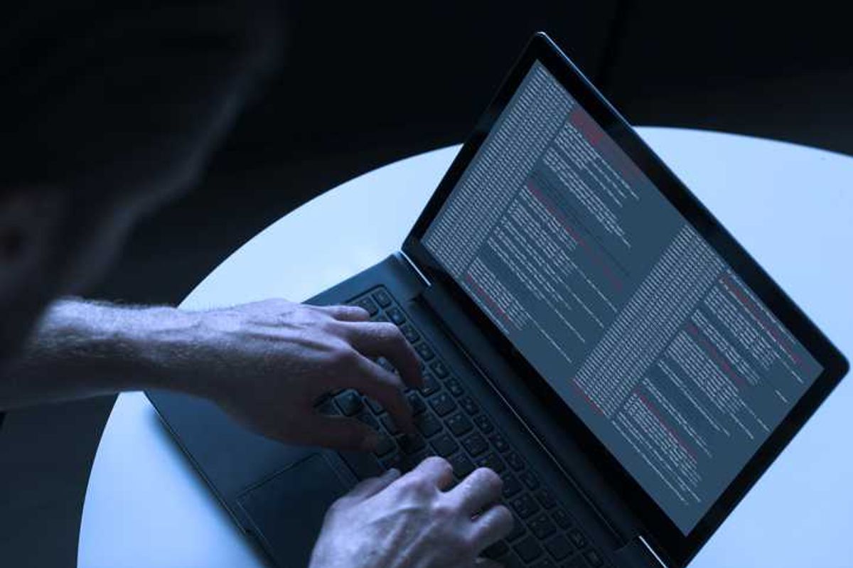 hacker uses laptop to hack computer network photo