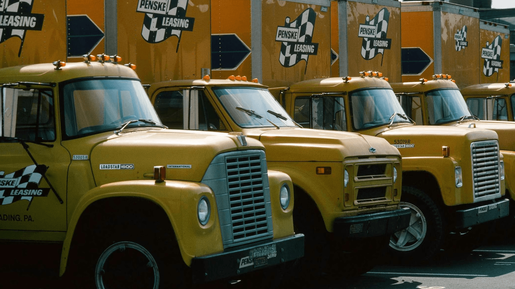 Old Penske box trucks in a parking lot