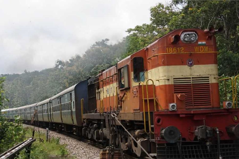 railroad tracks; rocks around train; train; cargo trains; rail road