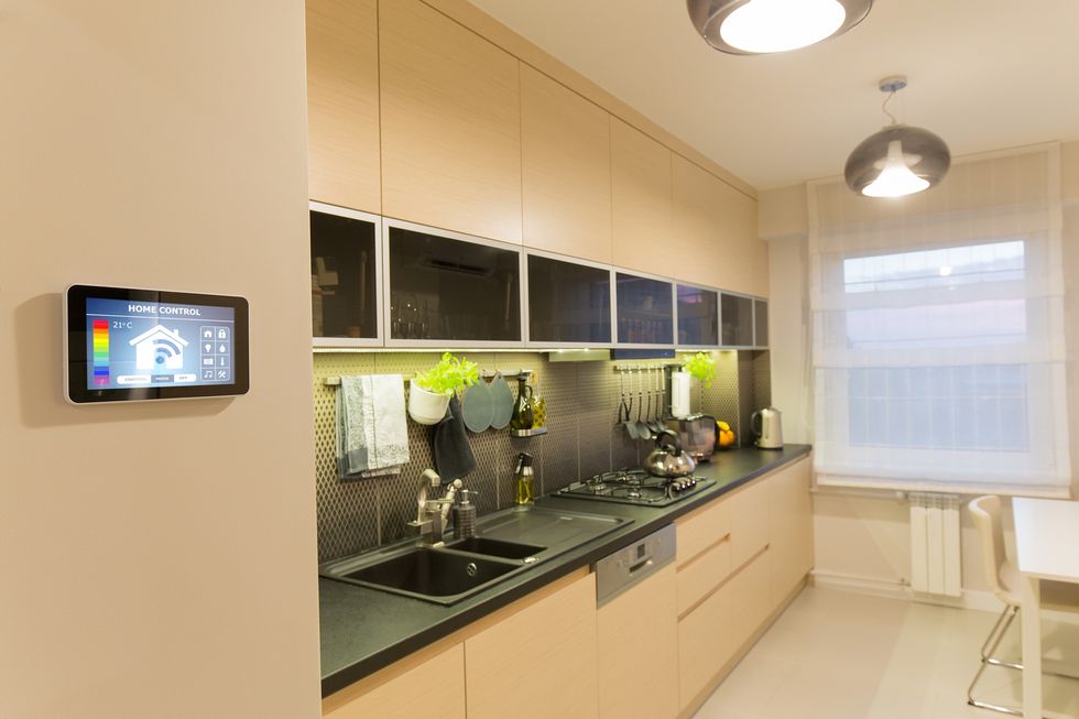 a photo of a smart kitchen with home security controller on the wall