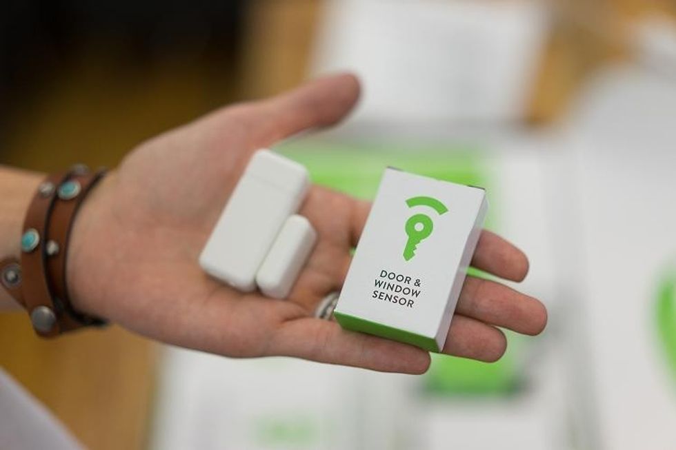 a photo of a person holding Frontpoint door and window sensor