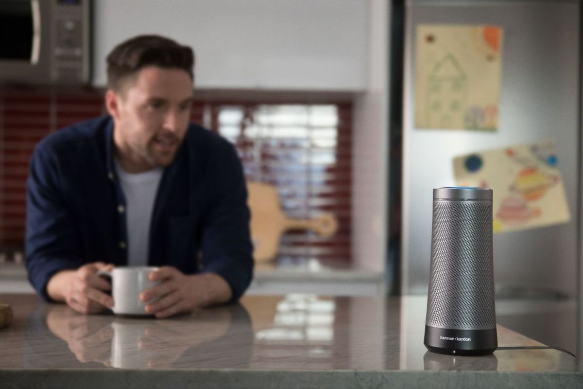 a photo of a man in a kitchen with Invoke Smart speaker