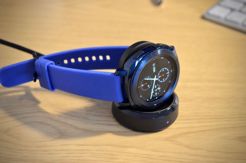 a photo of samsung gear sport smartwatch charging on a charger