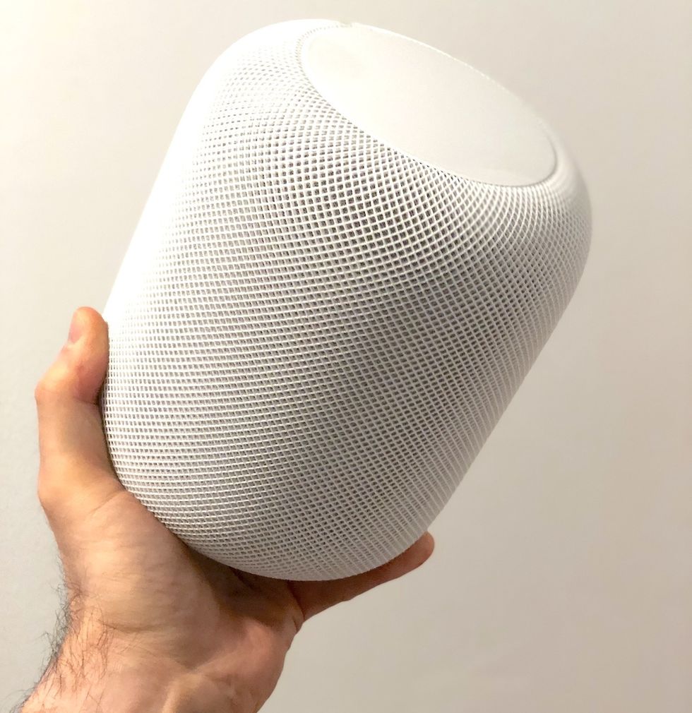 a photo of apple homepod in a man's hand