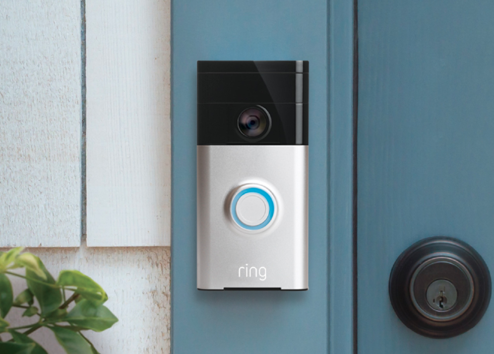 Picture of Ring video doorbell original next to a front door.
