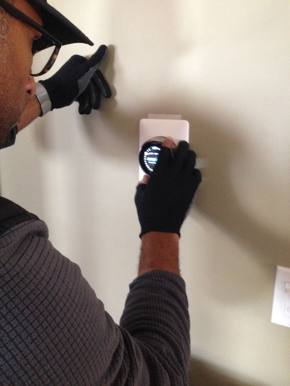 Vivint installing Nest Pro Thermostat on a wall.