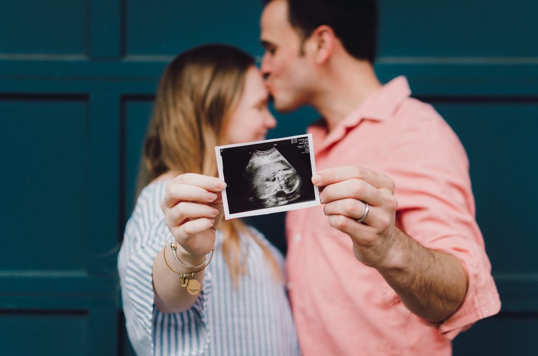 parents holding pregnancy ultrasound photo