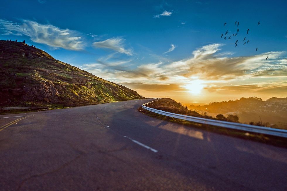 Long road while sun is setting in the distance