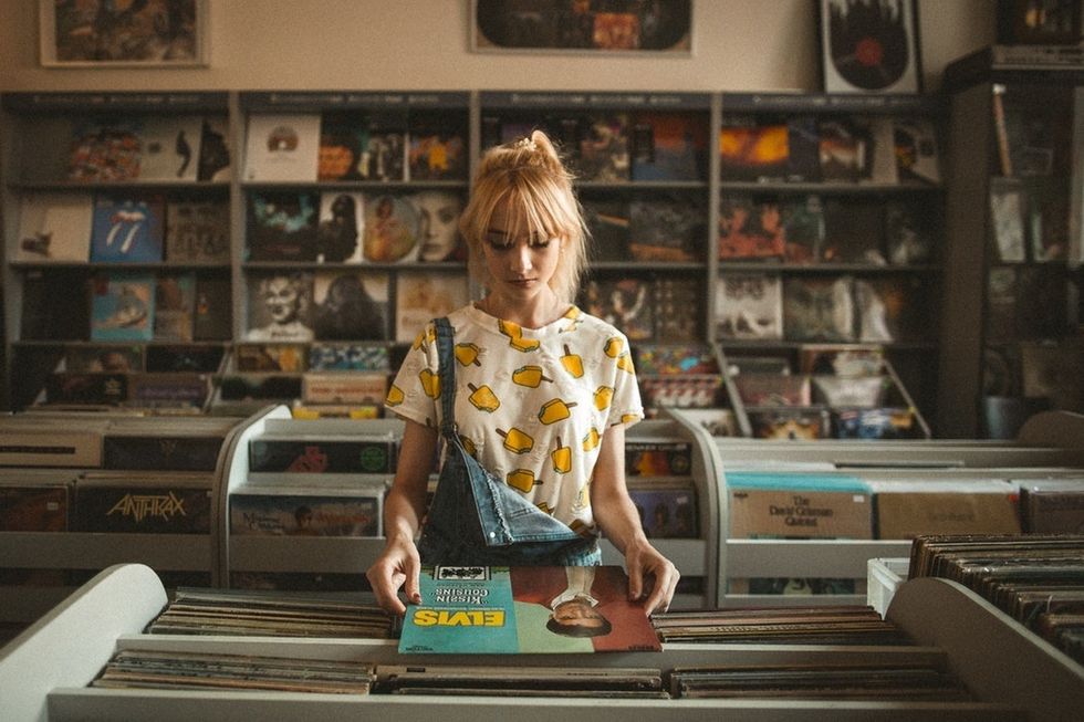 girl looking at elvis record in record store