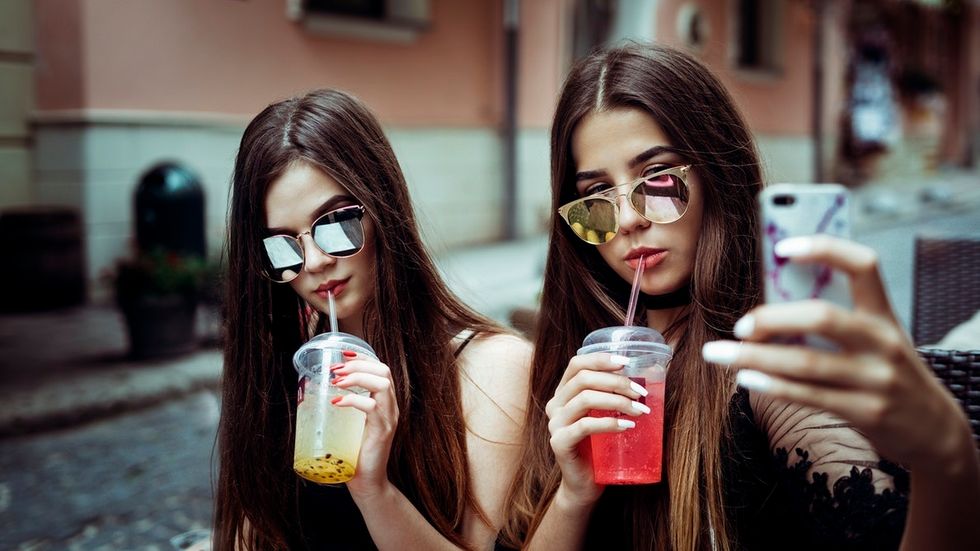 two girls drinking tea posing for selfie