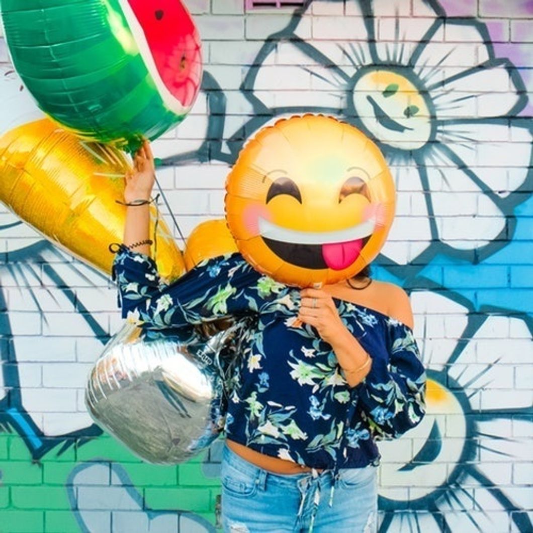 girl with smiley face balloon