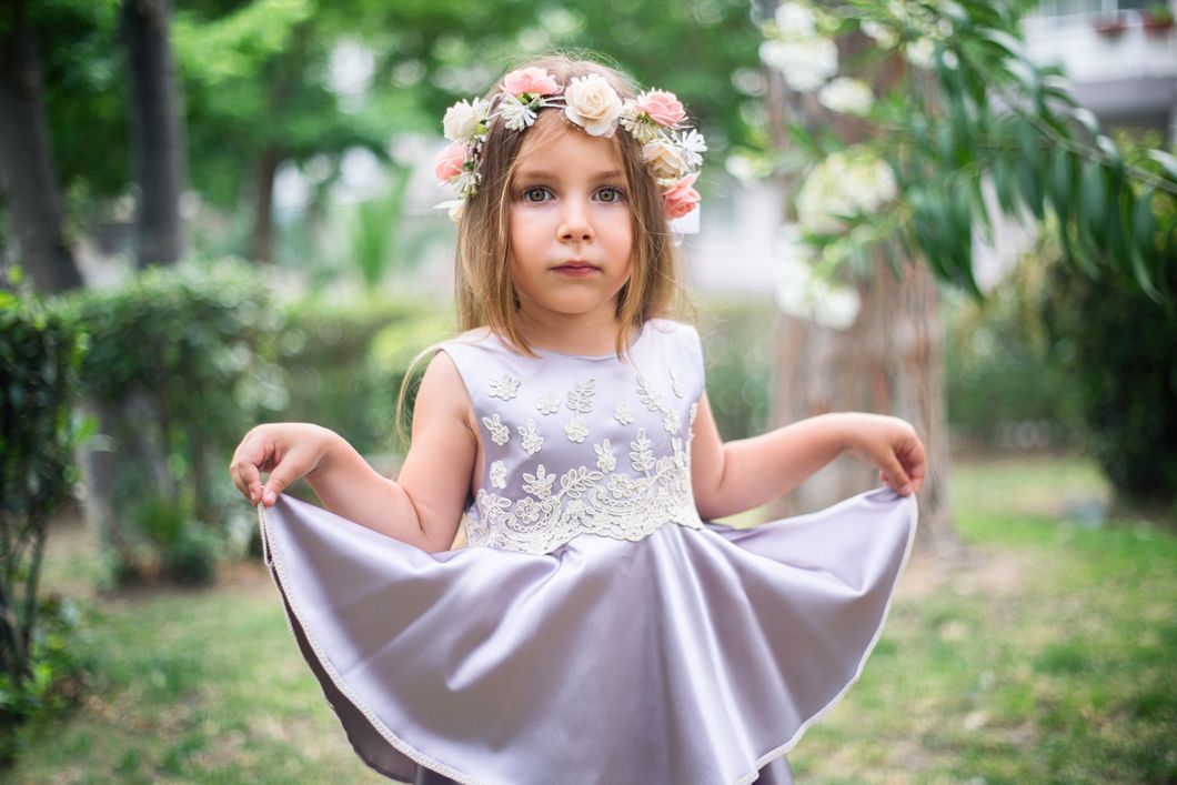 Little girl with flower crown holding up her dress