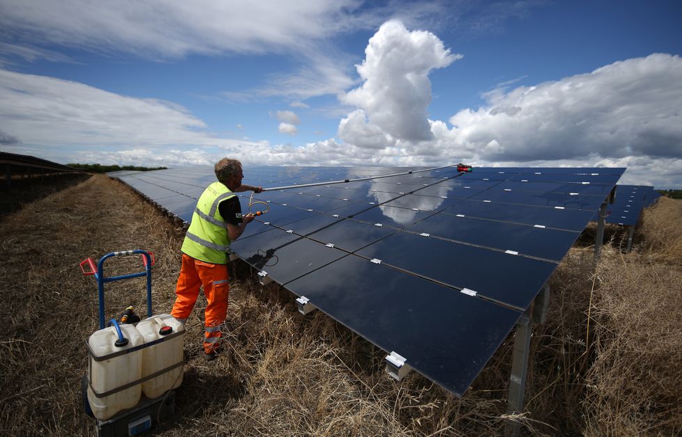 Man cleaning a solar panel array.