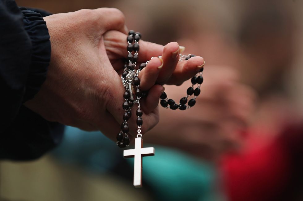 Hands holding a rosary.