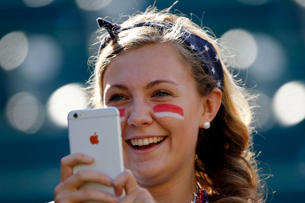 Girl taking a photo with her camera phone.