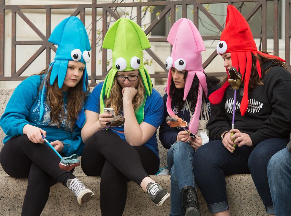 Teen girls wearing squid hats.