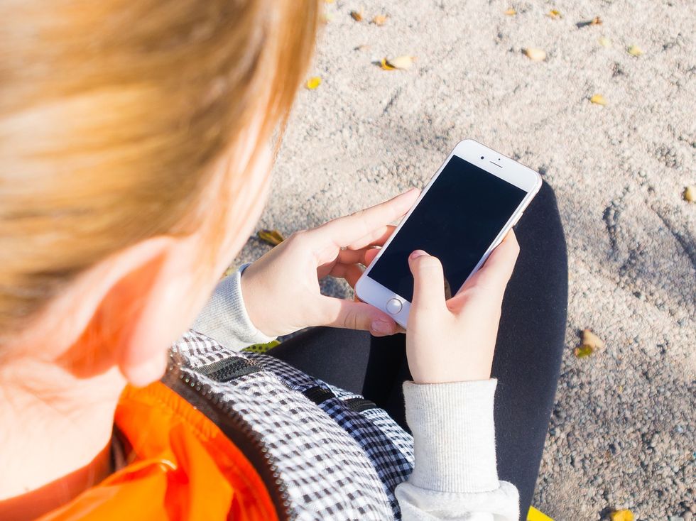 Girl looking at her smartphone on the beach.