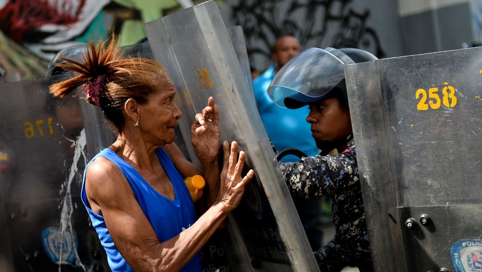 A woman confronts riot police during a protest in Caracas on December 28, 2017. Getty Images