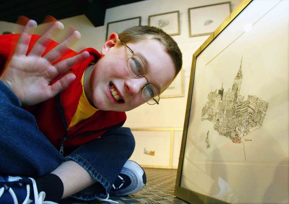 BIRMINGHAM, UNITED KINGDOM: Joshua Whitehouse (11) poses among his drawings at 'Number 9 Gallery' in Birmingham, 14 March 2002. The young artist suffering from a rare form of Autism called Aspergers syndrome have put all his artistic efforts on drawing Ne