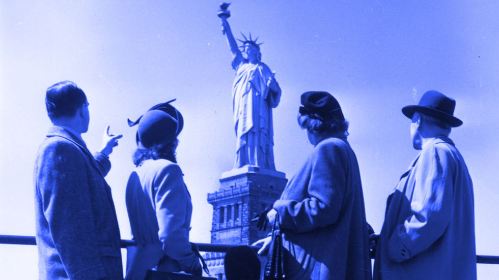 Immigrants admire the Statue of Liberty. (Getty Images)