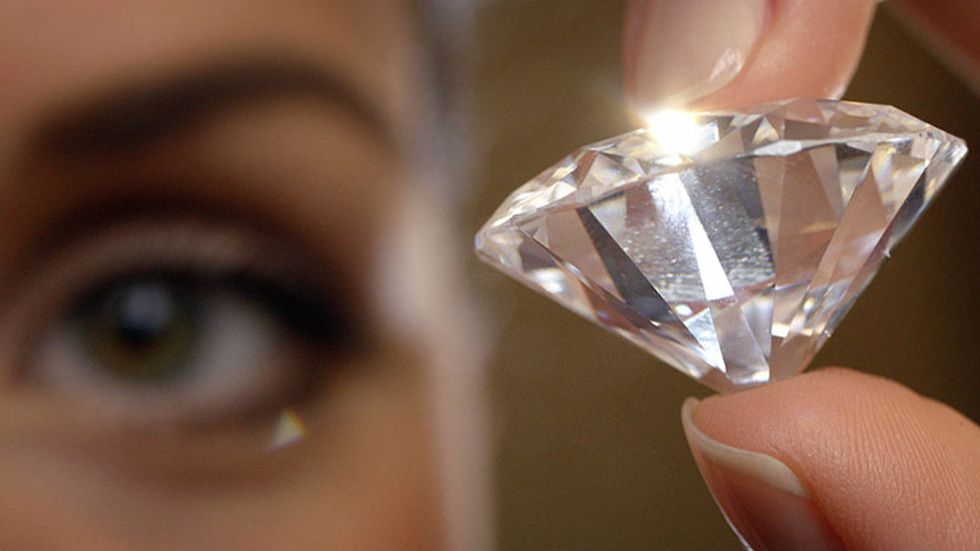 Woman holds up a diamond.