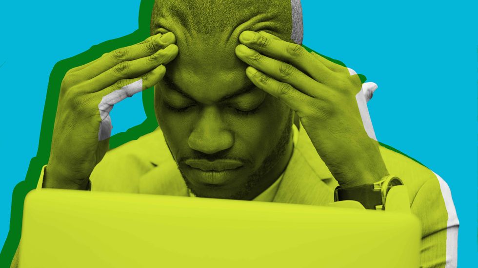 A man with his head down at his desk. (Shutterstock/Big Think)