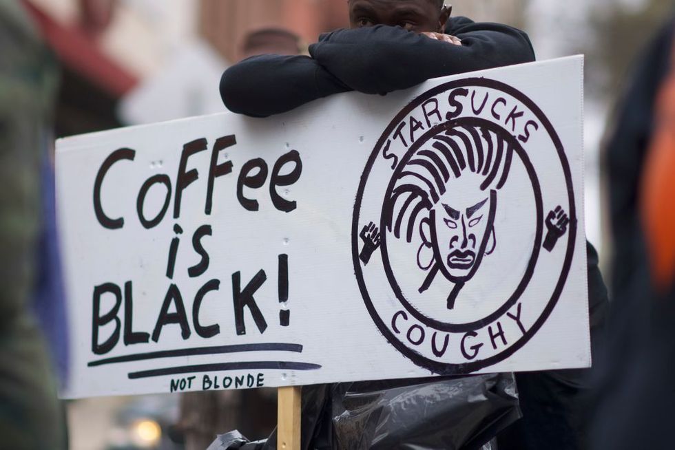 Protestor Jack Willis, 26, (C) demonstrates outside a Starbucks on April 15, 2018 in Philadelphia, Pennsylvania. Police arrested two black men who were waiting inside a Starbucks which prompted an apology from the CEO
