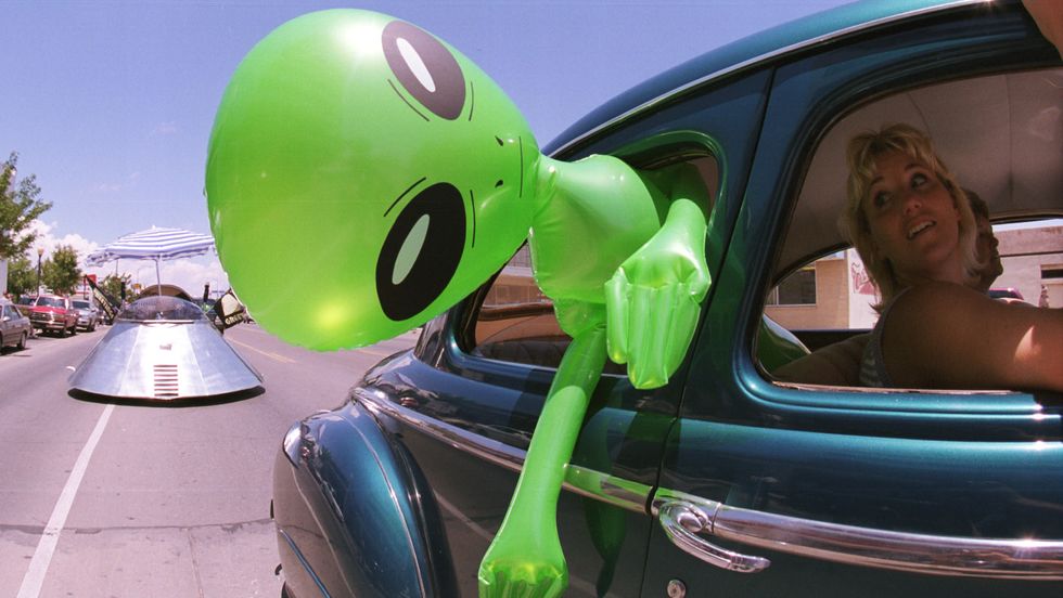 An alien doll hangs out a car window in downtown Roswell, New Mexico July 1, 2000. (Photo: Getty Images)