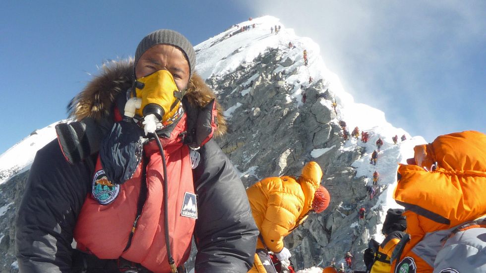 Nepalese mountaineer Pemba Dorje Sherpa (L) pauses at the Hillary Step while pushing for the summit of Everest on May 19, 2009, after climbing from the south face of Nepal. (Photo credit STR/AFP/Getty Images)