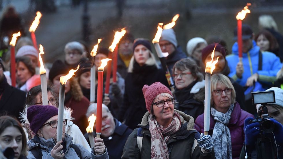 People hold of torches during a rally in support of #metoo and for all victims of sexual offenses in Stockholm, Sweden on January 14, 2018, as protests were organized in various towns and cities in Sweden. (Photo JONAS EKSTROMER/AFP/Getty Images)