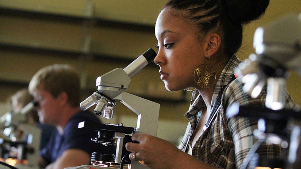 Southern Arkansas University Biology student with microscope.
