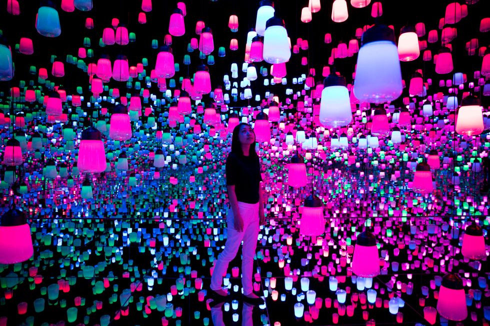 Woman walking around with lamps floating around her.