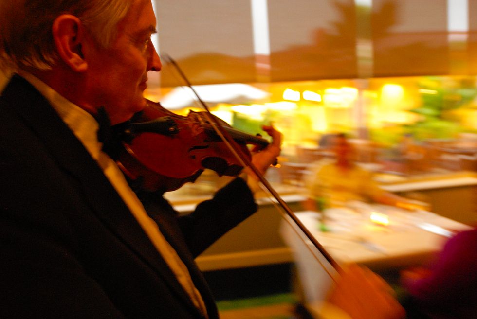 Joint Base Pearl Harbor. Hickam, Hawaii. A violinist entertains dinner guests.