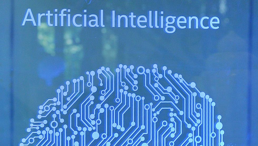A visitor at Intel's Artificial Intelligence (AI) Day walks past a signboard during the event in the Indian city of Bangalore on April 4, 2017. / AFP PHOTO / MANJUNATH KIRAN (MANJUNATH KIRAN/AFP/Getty Images)