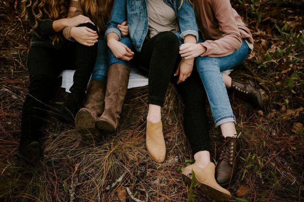3 friends sitting together in a field