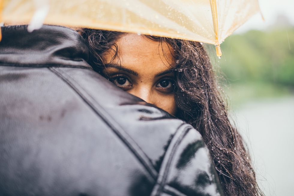 woman hugging boyfriend under umbrella
