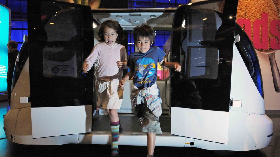 Children jump from a driverless car during a photocall at the Science Museum, in London. (CARL DE SOUZA/AFP/Getty Images)