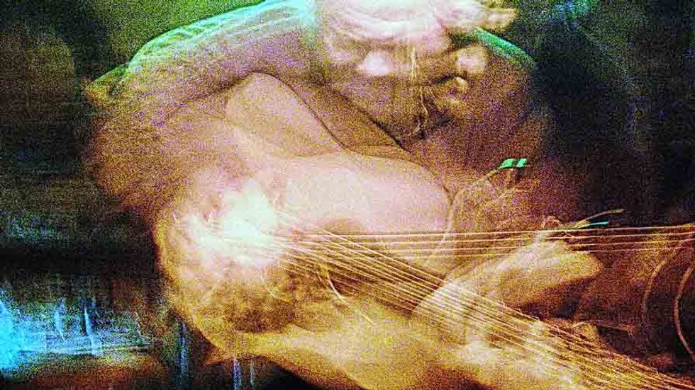 Blurry old man plays the guitar.